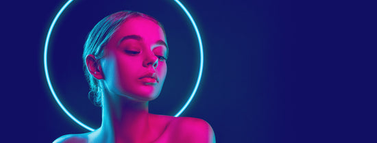 Woman with a neon pink ring around her head against a dark background